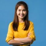 portrait-young-asia-lady-with-positive-expression-arms-crossed-smile-broadly-dressed-casual-clothing-looking-camera-blue-background-happy-adorable-glad-woman-rejoices-success_7861-2674